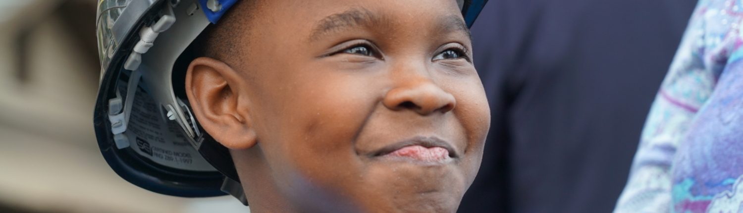 kid smiling with a hard hat on