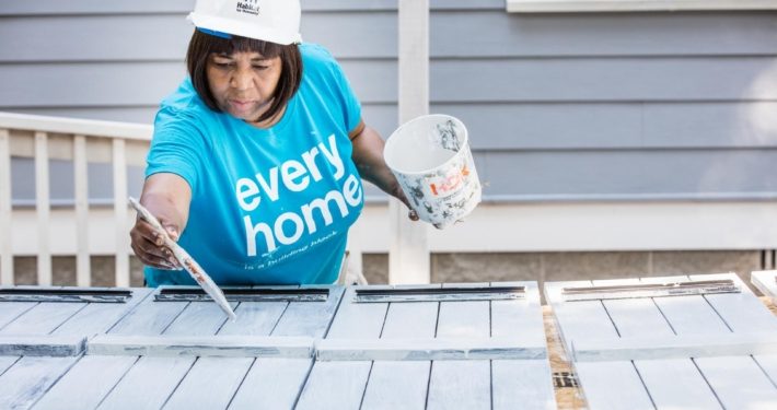 a volunteer painting shutters