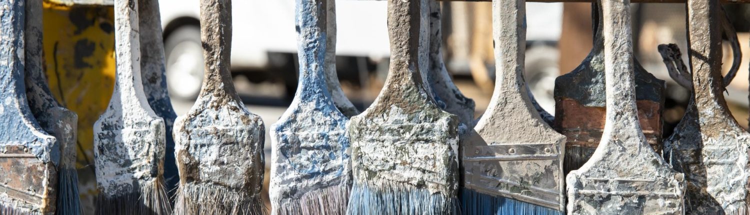 paint brushes hanging on nails