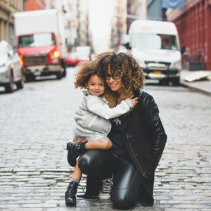 mom and daughter posing on the street