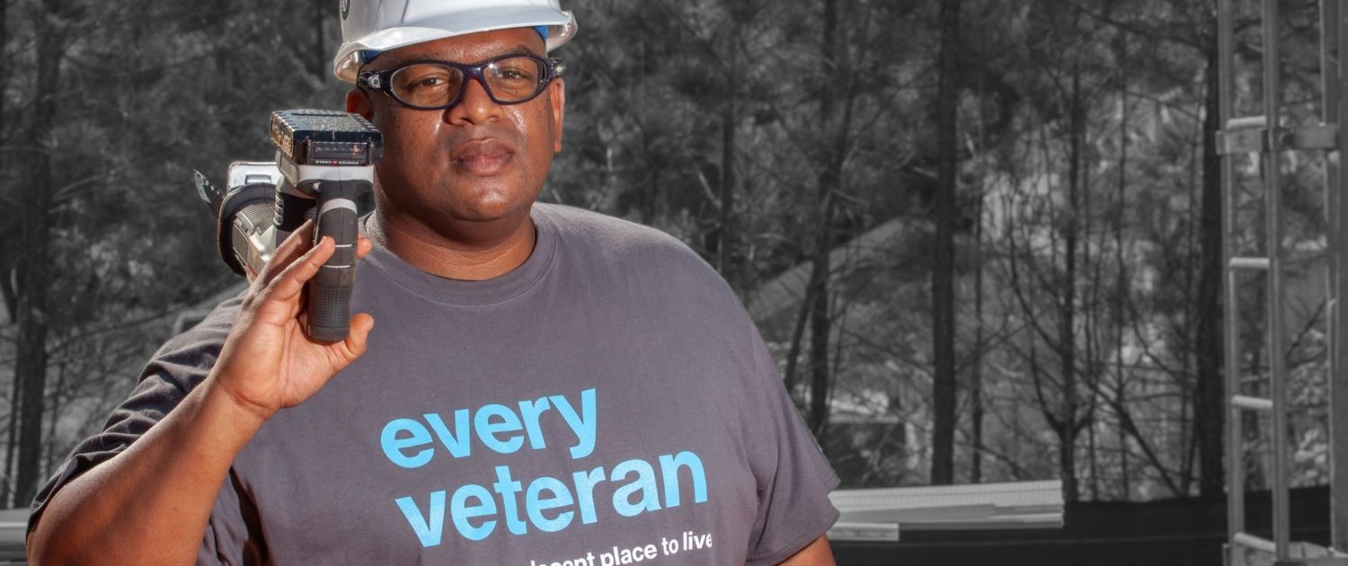 man in an every veteran deserves a decent place to live shirt with hard hat and tool