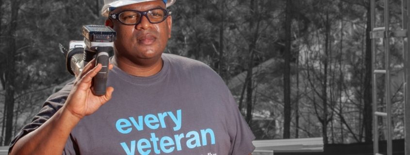 man in an every veteran deserves a decent place to live shirt with hard hat and tool