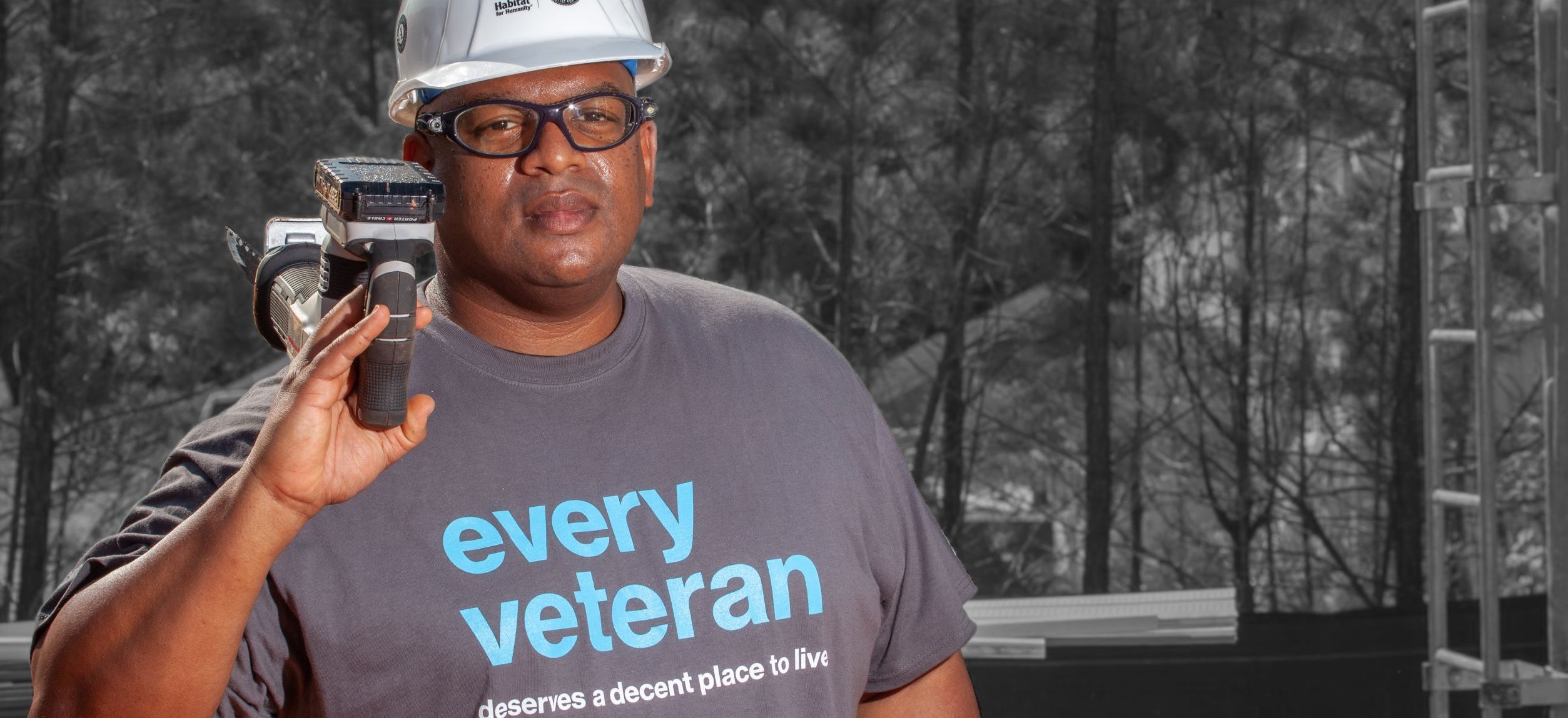 man in an every veteran deserves a decent place to live shirt with hard hat and tool