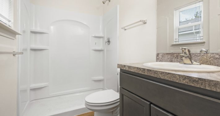 bathroom with shower, toilet, and sink