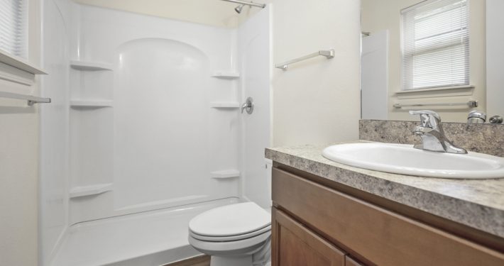 bathroom with shower, toilet, and sink