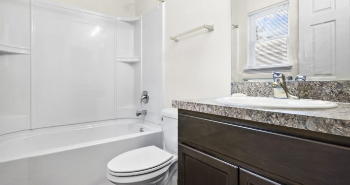 bathroom photo including shower, toilet, and vanity